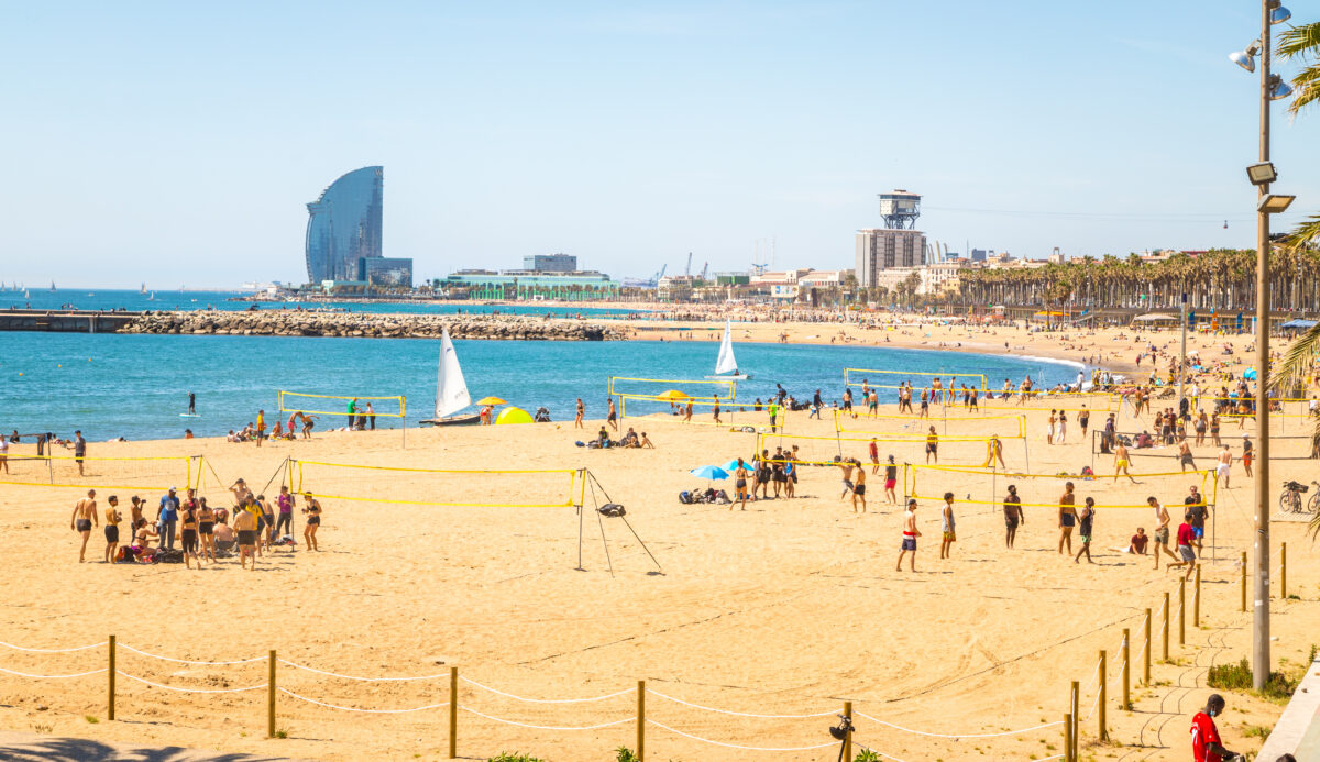 Busy Barceloneta Beach in Barcelona Spain showing crowds enjoying beach activities