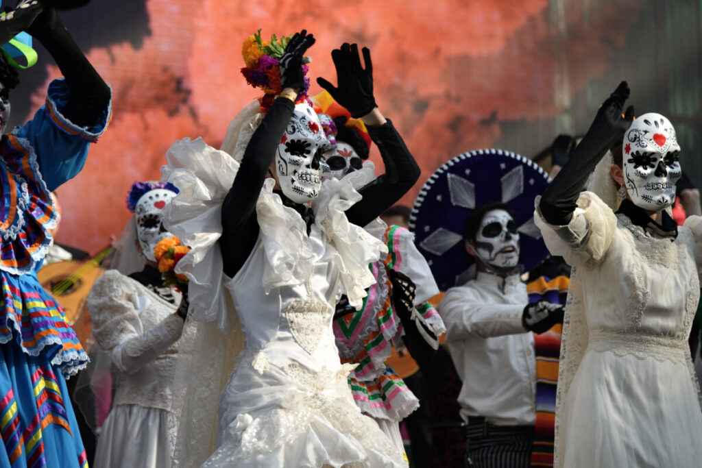 Vibrant Día de los Muertos carnival in Mexico with a parade of people in skeleton masks and make-up, celebrating Day of the Dead traditions