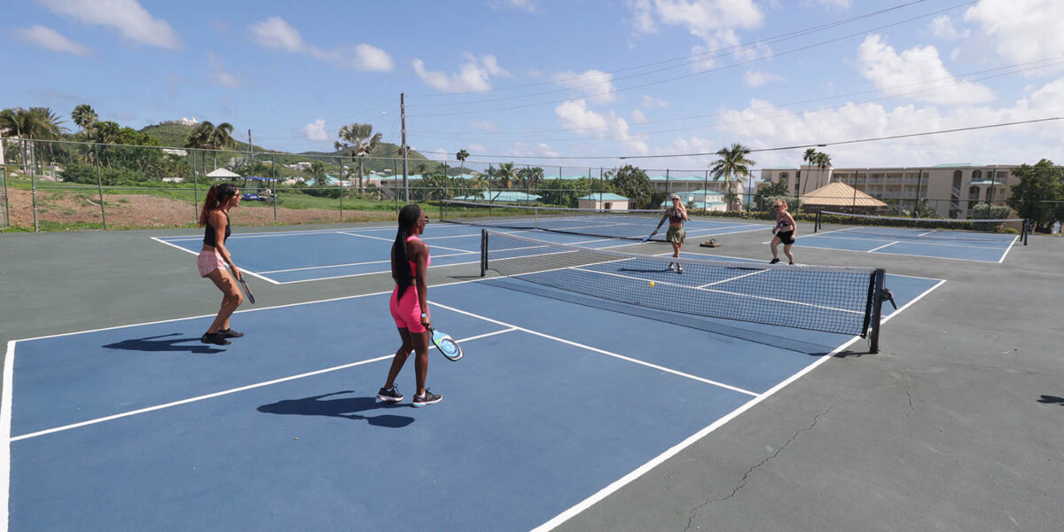 Guests playing tennis at Divi Carina Bay Beach Resort's professional courts