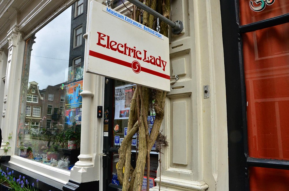 Front view of Electric Ladyland, the First Museum of Fluorescent Art, featuring its vibrant sign and welcoming entrance
