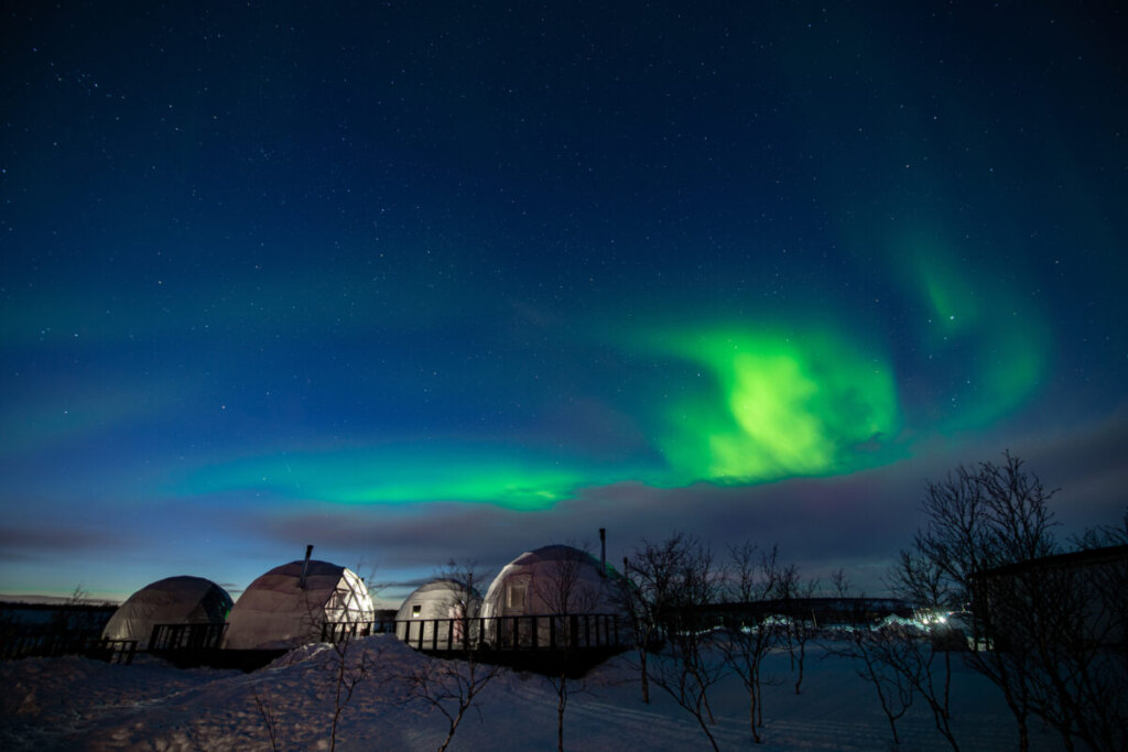 Panoramic view of the Northern lights and Igloos in Finland