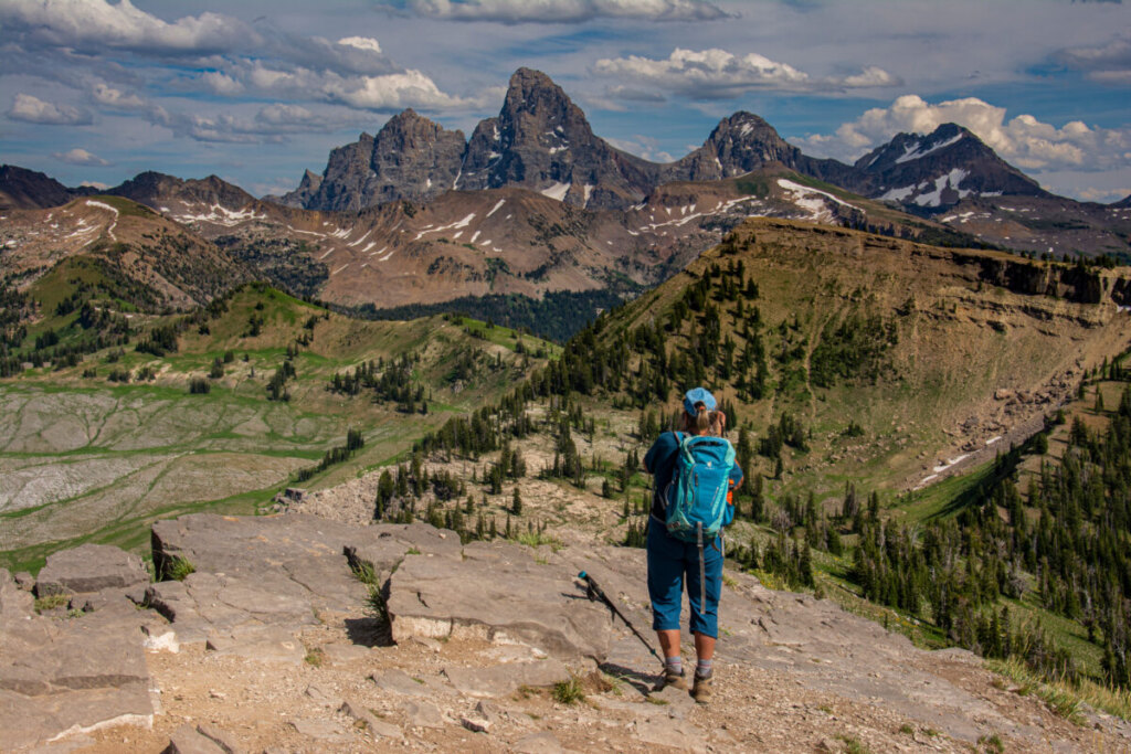 Backpackers hiking Cascade Canyon trail in Grand Teton National Park with wildflowers and mountain peaks