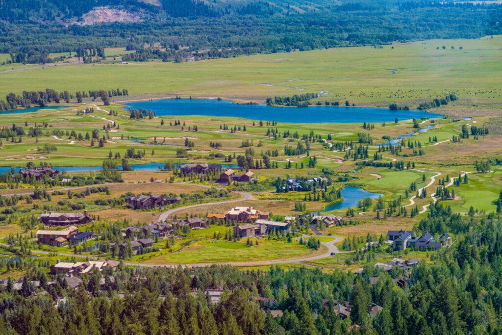 Aerial tram ascending Jackson Hole Mountain Resort with panoramic valley views and ski runs visible below
