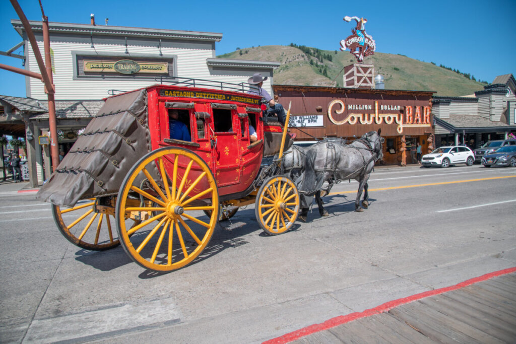 Horse-drawn carriage tour through downtown Jackson with antler arches and western storefronts