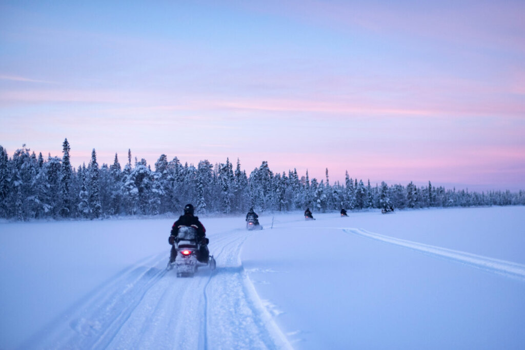 Group enjoying a snowmobiling activity on a frozen lake in Torassieppi, Lapland, Finland