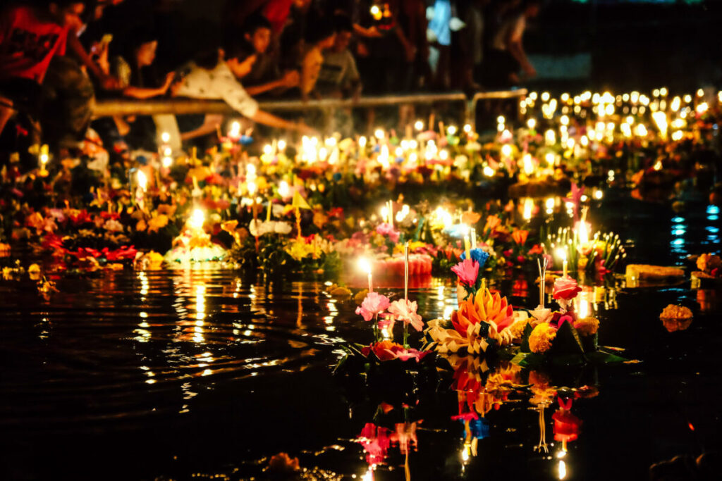 Close-up of small decorative baskets being released into the water to float, celebrating the Loy Krathong Festival in Thailand
