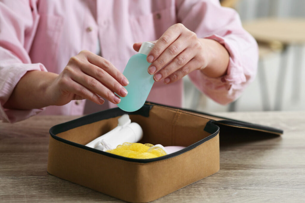 Woman carefully packs her toiletries into a small travel bag, ensuring she has all necessary items for her trip