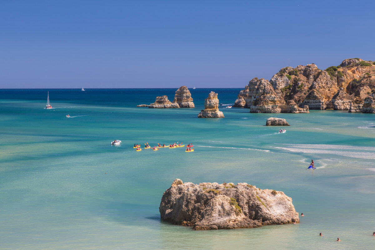 Canoes in the turquoise water of the Atlantic Ocean surrounding Praia Dona Ana beach Lagos Algarve Portugal Europe