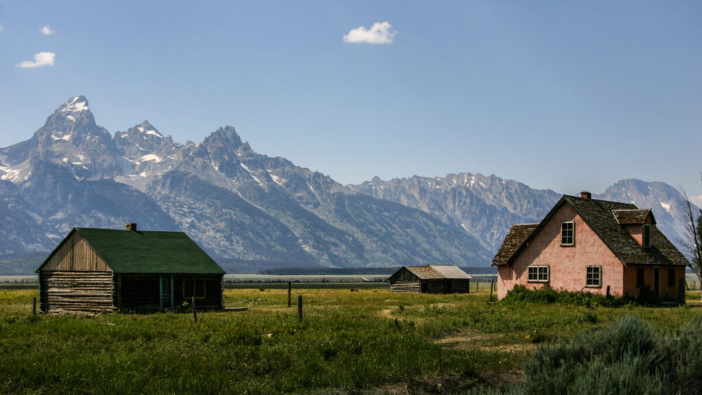 Scenic Snake River float trip passing historic Moulton Barn with Teton Range reflected in calm waters