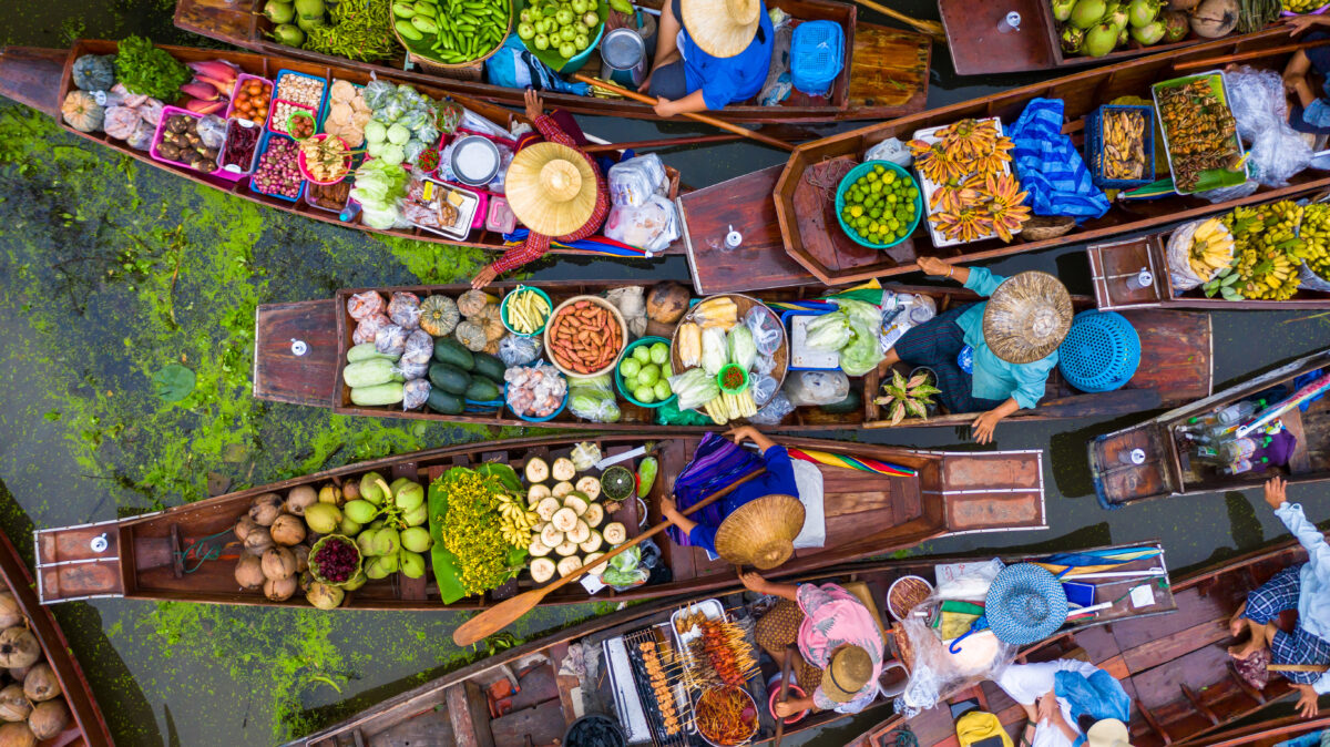Local vendors selling fresh produce at authentic Thai floating market