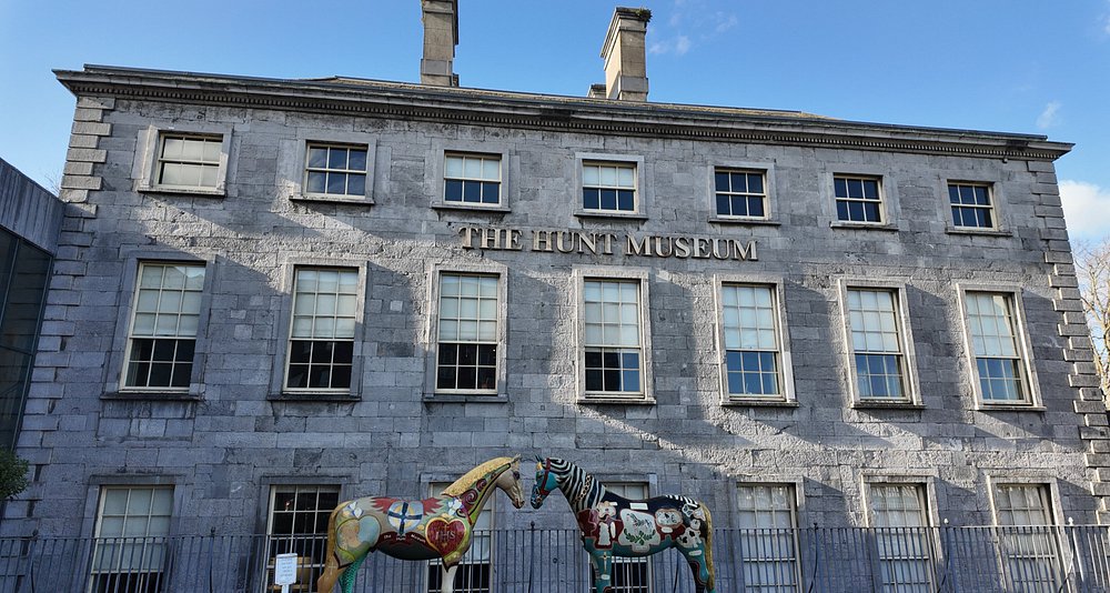 The Hunt Museum's elegant exterior in Limerick, Ireland, showcasing classic architecture and surrounding greenery
