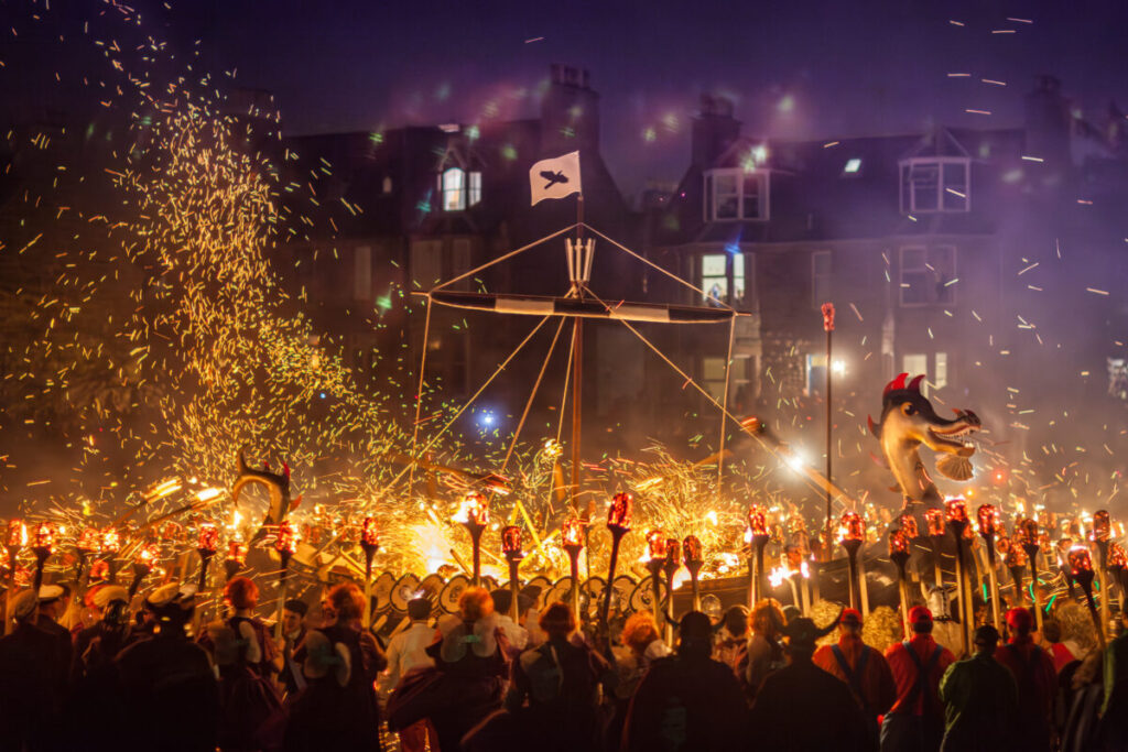 Crowd gathered to celebrate the Up Helly Aa Festival in Shetland, Scotland, watching the traditional burning of a Viking ship