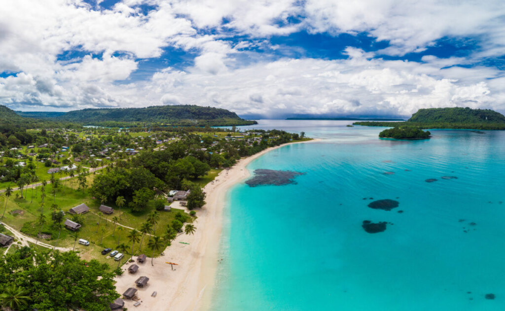 Port Orly sandy beach with palm trees, Espiritu Santo Island, Vanuatu.